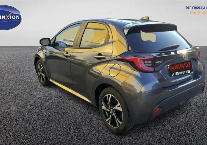 Vue 3/4 arrière droite d'une Toyota Yaris hybride 116h Design gris foncé avec jantes alliage et feux LED distinctifs.