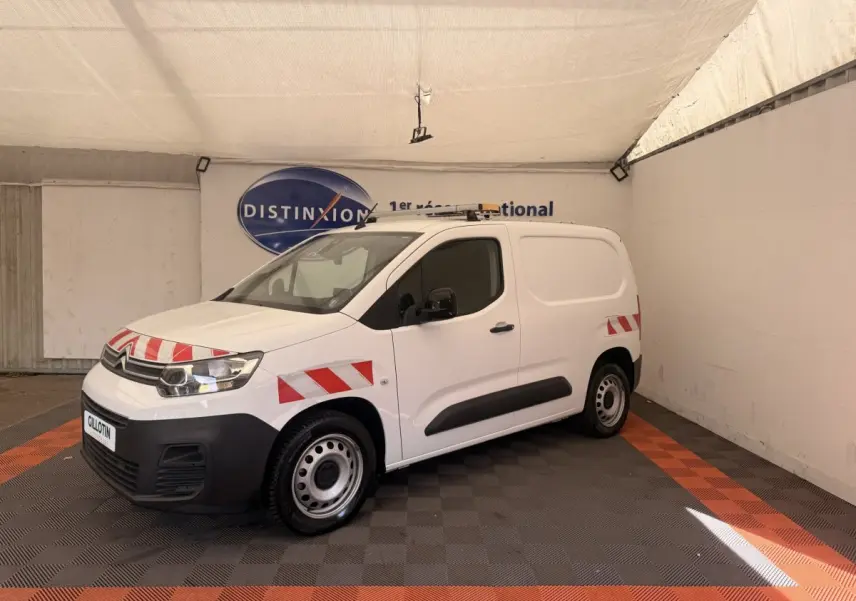 Fourgon Citroën Berlingo blanc en 3/4 avant gauche avec bandes rouges réfléchissantes et jantes acier.