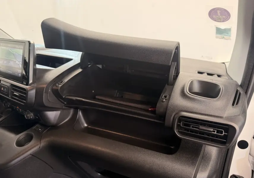 Intérieur du Citroën Berlingo 2022 blanc, vue côté passager avec boîte à gants ouverte et tableau de bord noir.