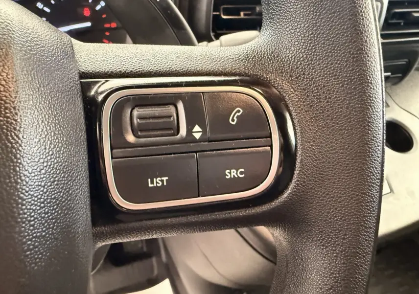 Gros plan sur les commandes gauche du volant noir du Citroën Berlingo 2022, boutons de gestion audio et appel.