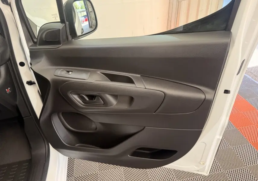 Vue rapprochée de la porte avant gauche noire du Citroën Berlingo blanc 2022, avec rétroviseur électrique.