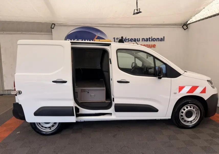 Vue latérale droite d’un Citroën Berlingo blanc 2022 avec porte coulissante ouverte et marquage rouge réfléchissant sur l’aile avant.