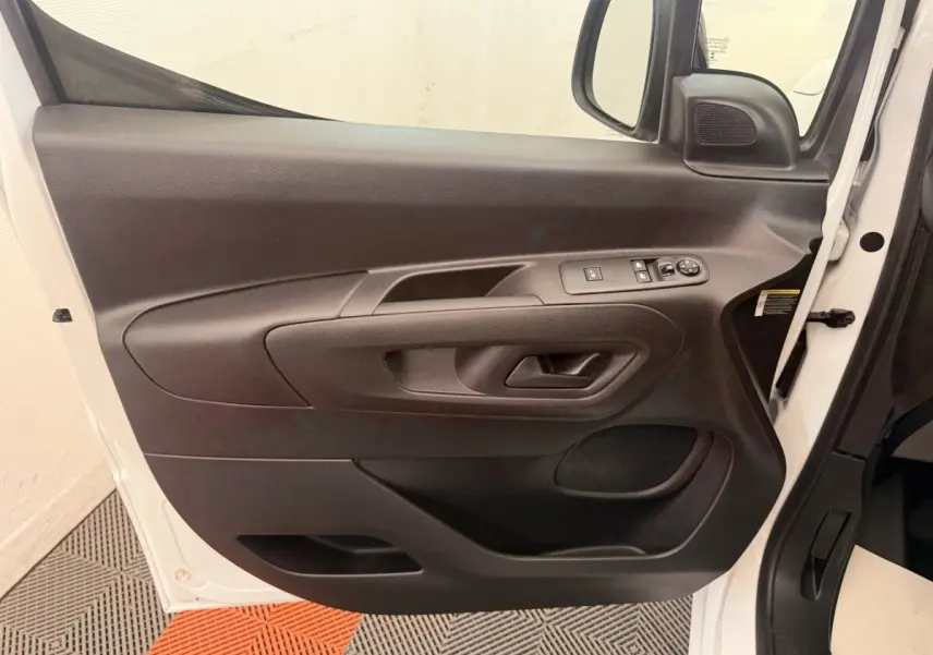 Vue rapprochée de la porte avant gauche noire du Citroën Berlingo blanc 2022 avec commandes électriques.