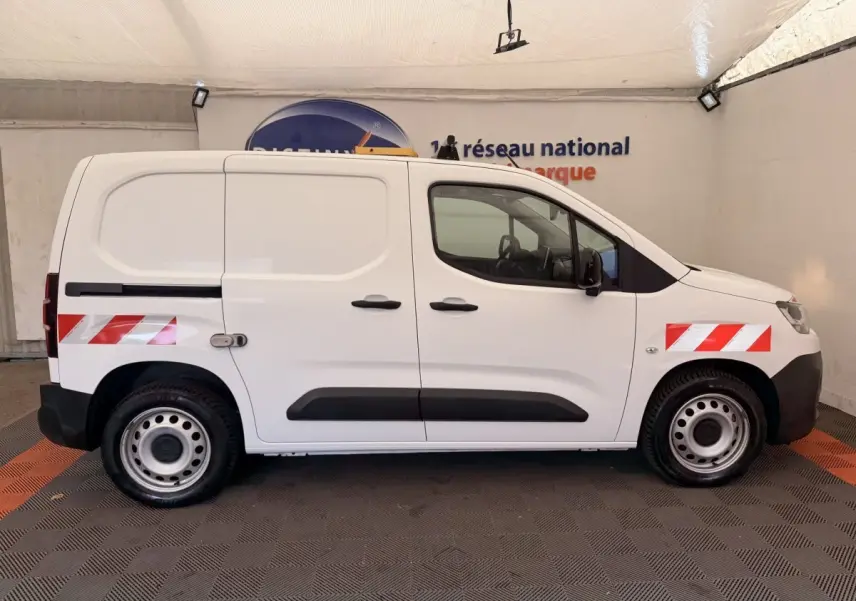 Vue de profil côté droit d’un Citroën Berlingo blanc 2022 avec bandes réfléchissantes rouges sur ailes avant et arrière.