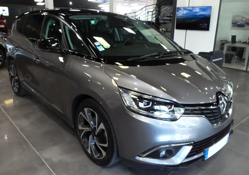Vue 3/4 avant gauche du Renault Grand Scenic IV gris Cassiopé avec toit noir et jantes alliage distinctives.