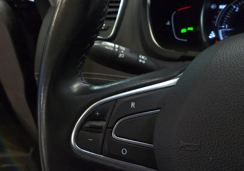 Gros plan sur les commandes au volant en cuir noir du Renault Grand Scenic IV 2020, version diesel.