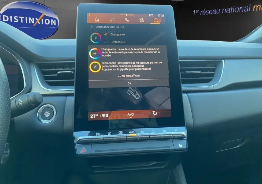 Vue intérieure centrée sur l'écran tactile vertical du tableau de bord de la Renault Symbioz gris Casiopee, avec commandes climatisation visibles.