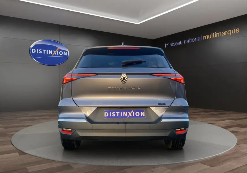 Vue arrière d'une Renault SYMBIOZ gris Casiopee avec feux arrière fins et logo centré dans un showroom.