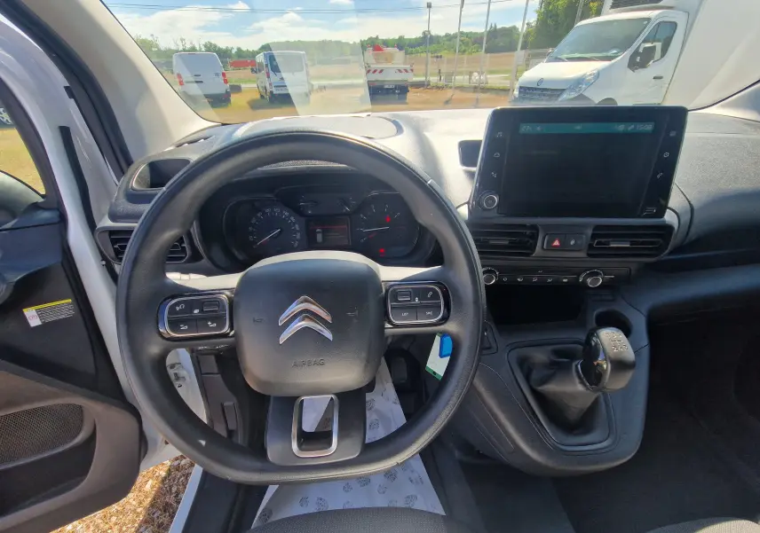 Vue intérieure du poste de conduite du Citroën Berlingo blanc 2020, avec volant multifonction et écran tactile central.