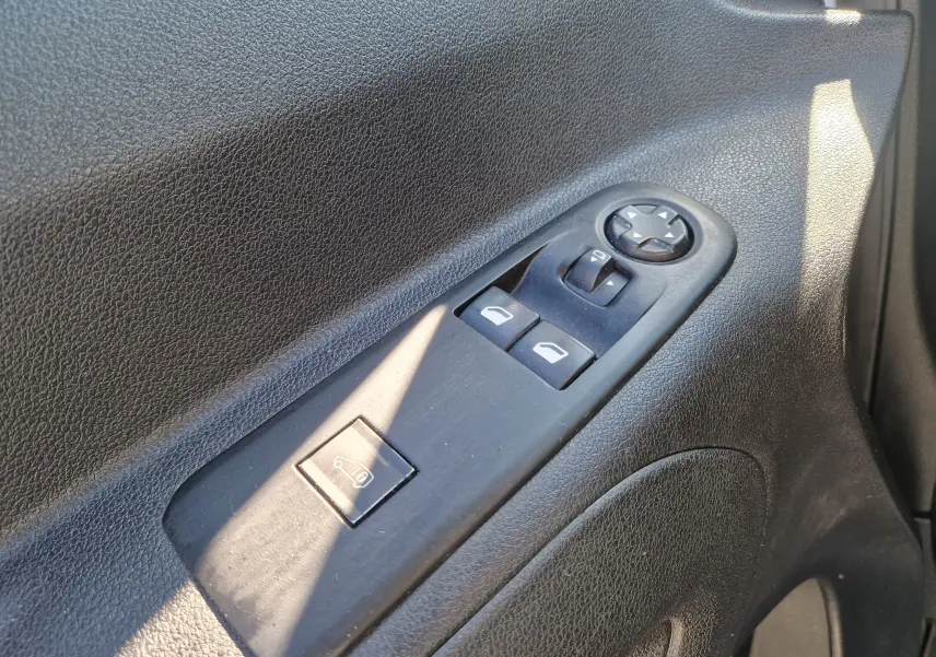 Gros plan sur les commandes de lève-vitres et réglage des rétroviseurs côté conducteur d’un Citroën Berlingo blanc 2020.