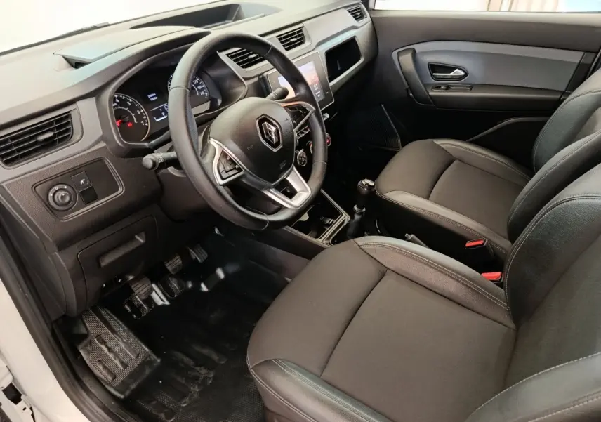 Vue intérieure côté conducteur du Renault Express blanc 2023, volant multifonctions et sièges noirs en tissu.