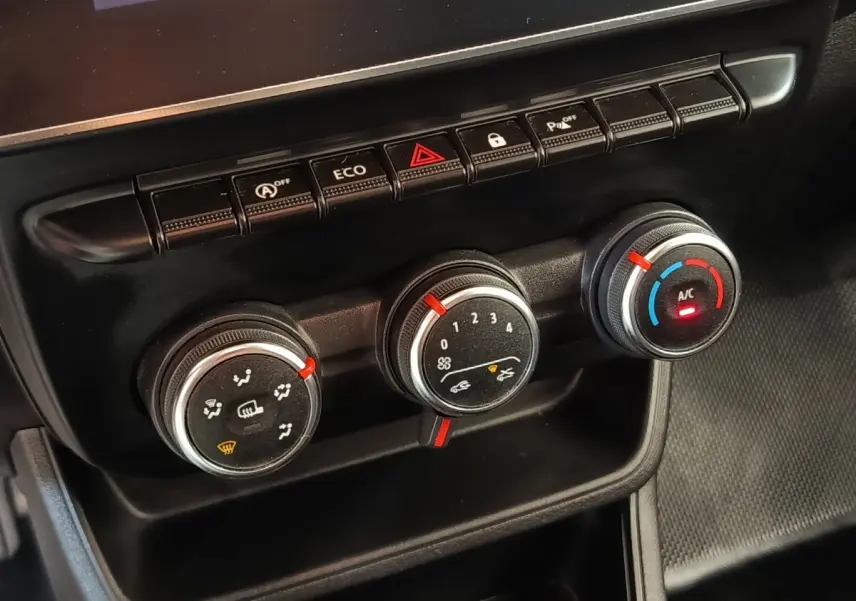 Gros plan sur les commandes de climatisation et boutons de fonction du tableau de bord du Renault Express blanc 2023.