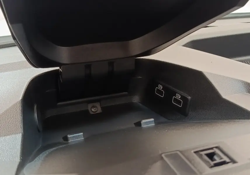 Gros plan sur le compartiment de rangement ouvert avec deux ports USB à l'avant du tableau de bord noir.