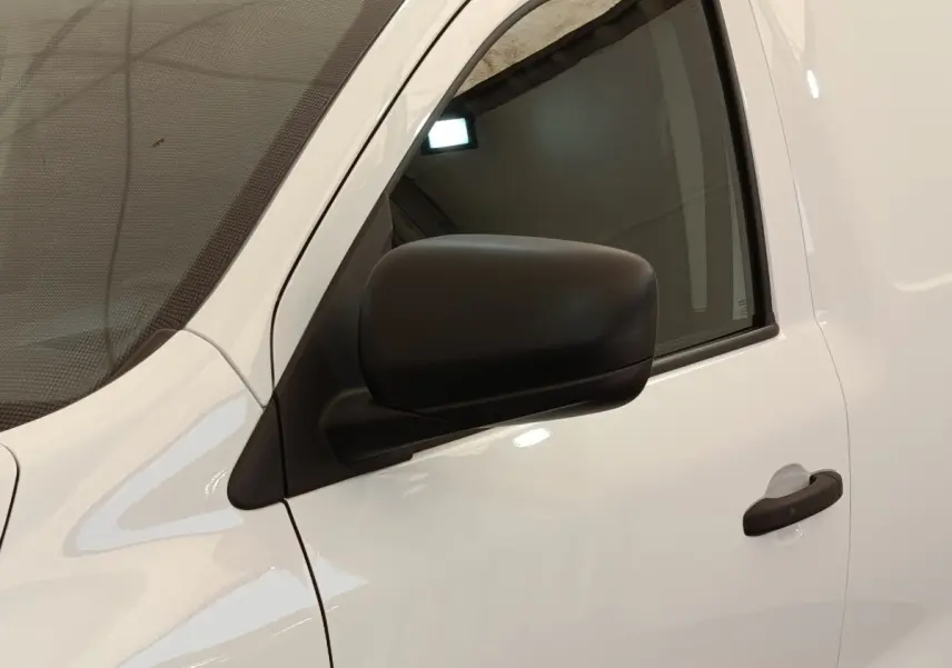 Vue rapprochée du côté gauche d’un Renault Express blanc, mettant en valeur la portière et le rétroviseur noir.