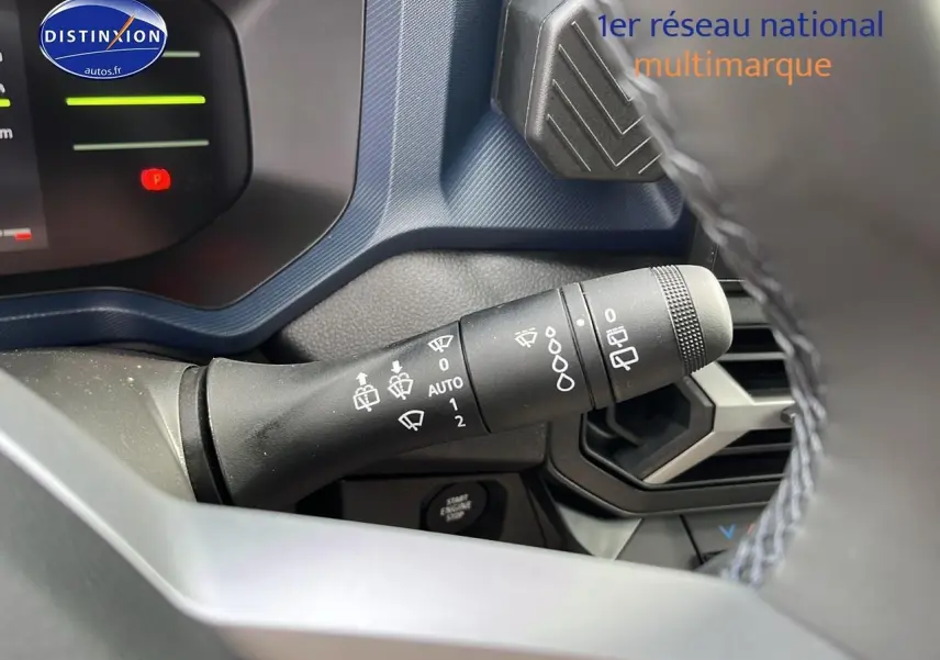 Gros plan sur la manette d'essuie-glace du tableau de bord du Dacia Duster 2025, intérieur gris et bleu.