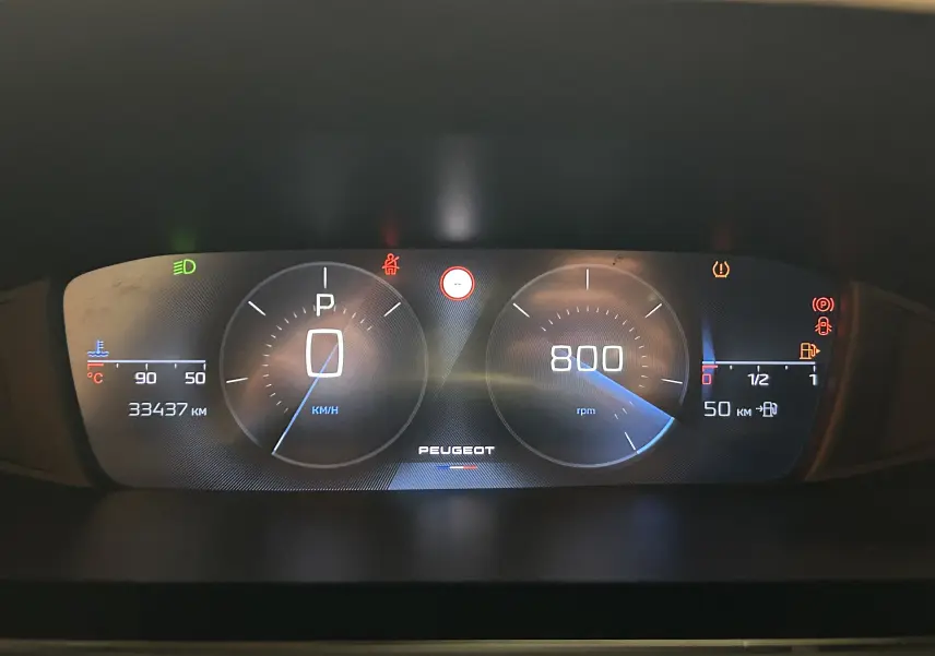 Tableau de bord numérique du Peugeot 308 rouge 2024, affichant vitesse, régime moteur et jauges, avec voyants allumés.
