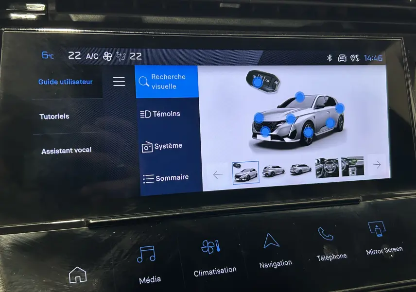 Écran tactile intérieur montrant l'interface multimédia avec une Peugeot 308 blanche en vue 3/4 avant.