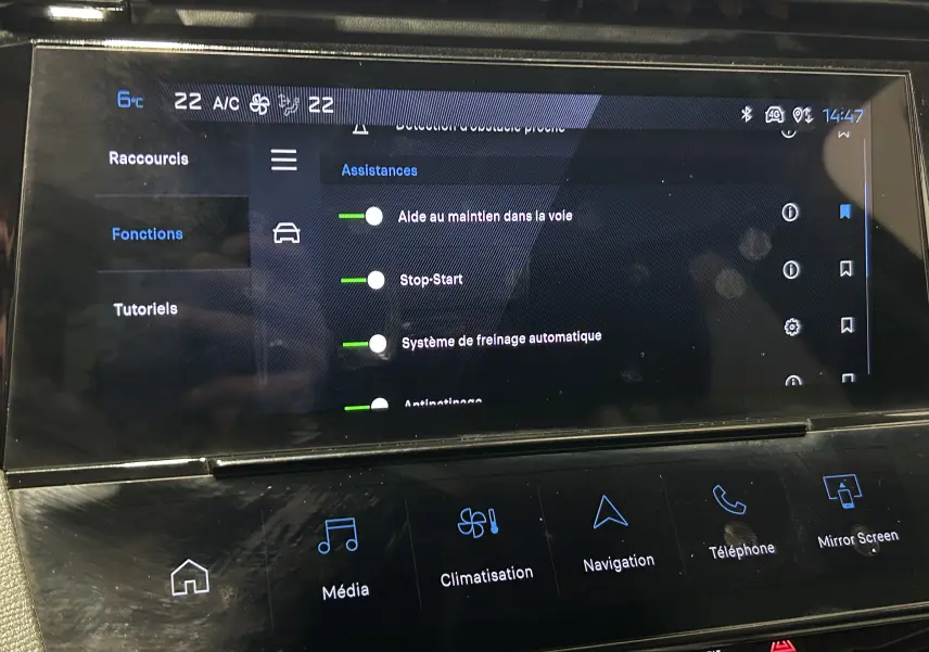 Écran tactile central de la Peugeot 308 2024 rouge montrant les assistances à la conduite et options multimédia.