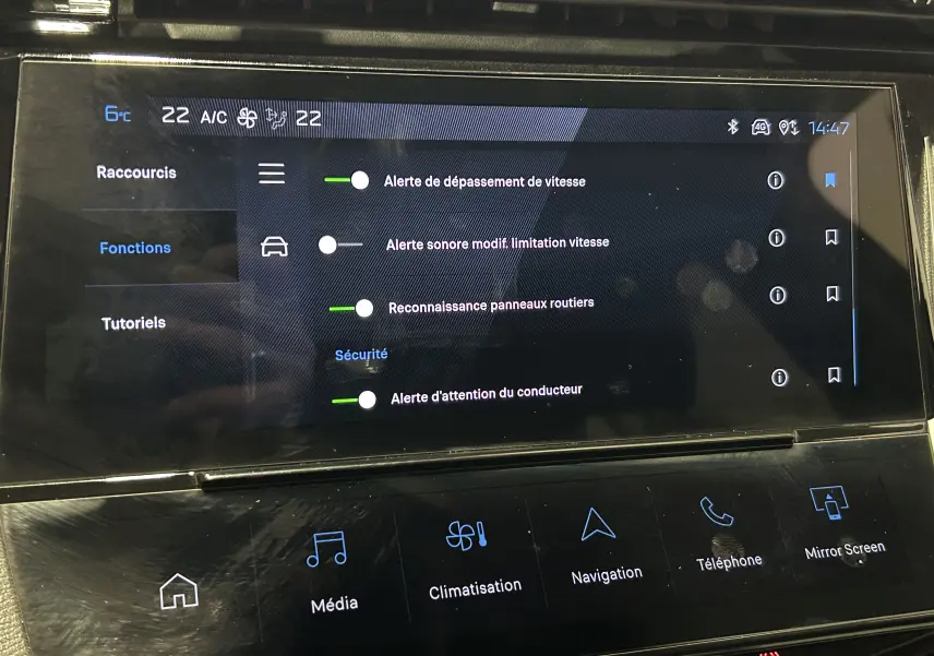 Écran tactile intérieur de la Peugeot 308 2024 montrant les réglages d’alerte de sécurité et la climatisation.