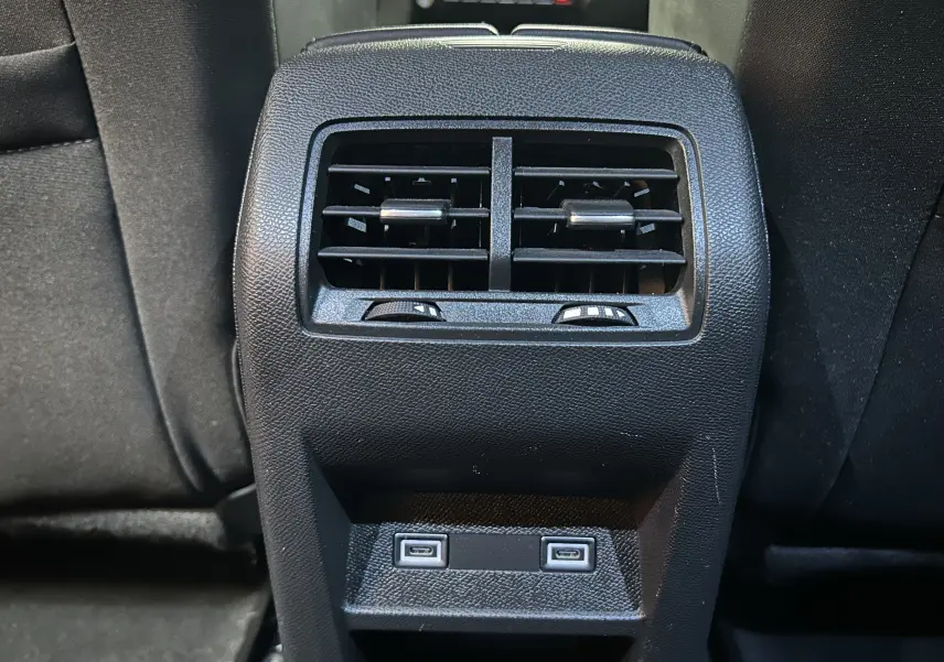 Détail de la console arrière avec bouches d’aération et deux ports USB-C dans une Peugeot 308 rouge 2024.