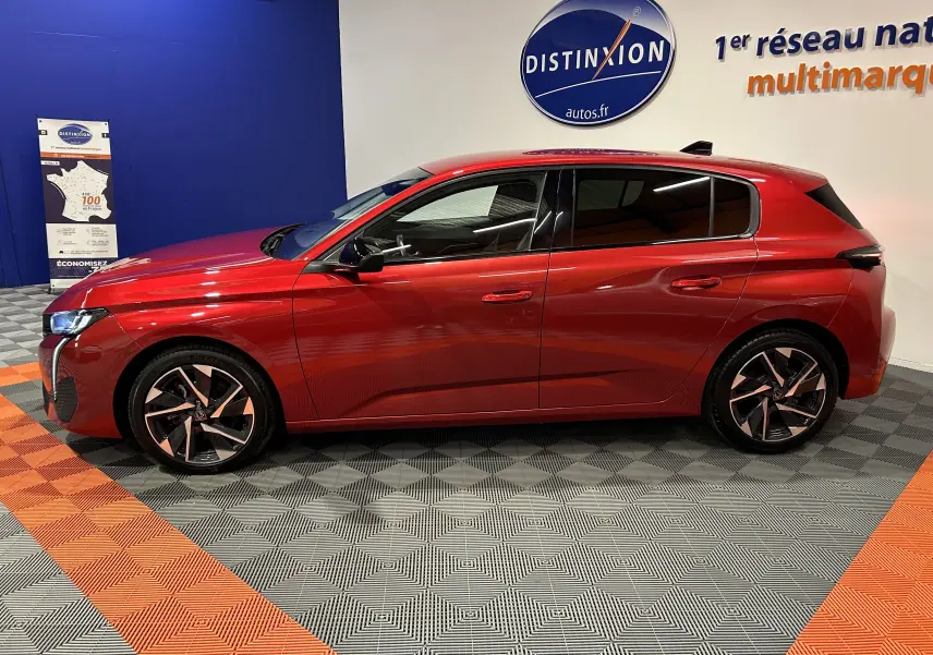 Profil droit d'une Peugeot 308 rouge 2024, version BlueHDi 130 EAT8 Allure, avec jantes alliage et vitres teintées.