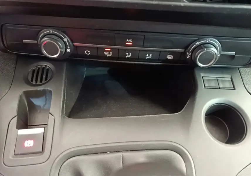 Vue rapprochée de la console centrale noire du Citroën Berlingo XL 2020, avec commandes climatisation et porte-gobelet.