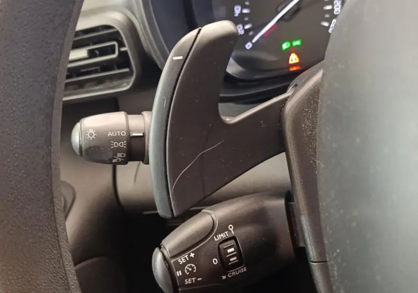 Gros plan sur les commandes au volant du Citroën Berlingo 2020, montrant palettes et régulateur de vitesse.