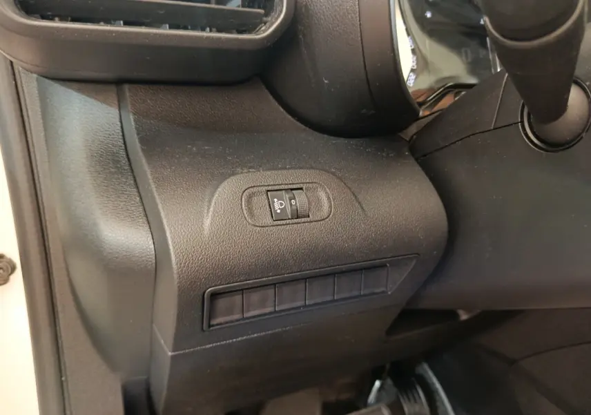 Détail du tableau de bord côté gauche du Citroën Berlingo blanc 2020, avec commande de réglage hauteur des phares.