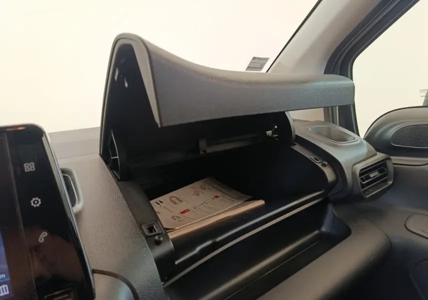 Intérieur du Citroën Berlingo 2020, vue sur la boîte à gants ouverte côté passager avec documents visibles.