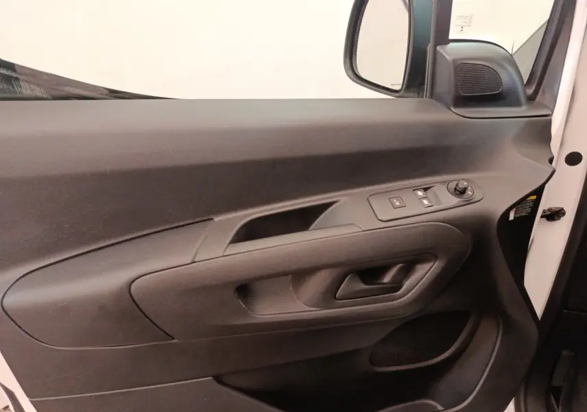 Vue intérieure côté conducteur de la porte noire du Citroën Berlingo blanc avec commandes électriques des vitres et rétroviseur.