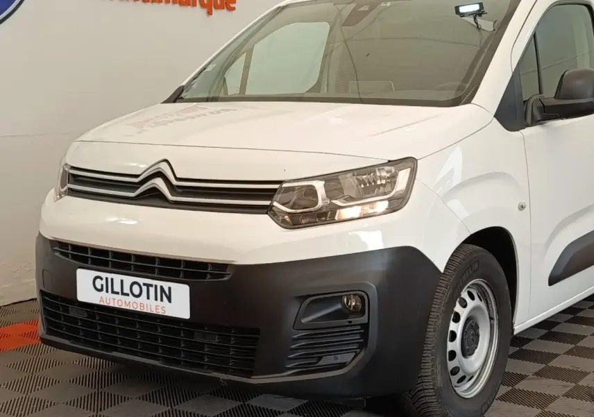 Vue 3/4 avant droit d'un Citroën Berlingo blanc avec pare-chocs noir et jante acier simple.