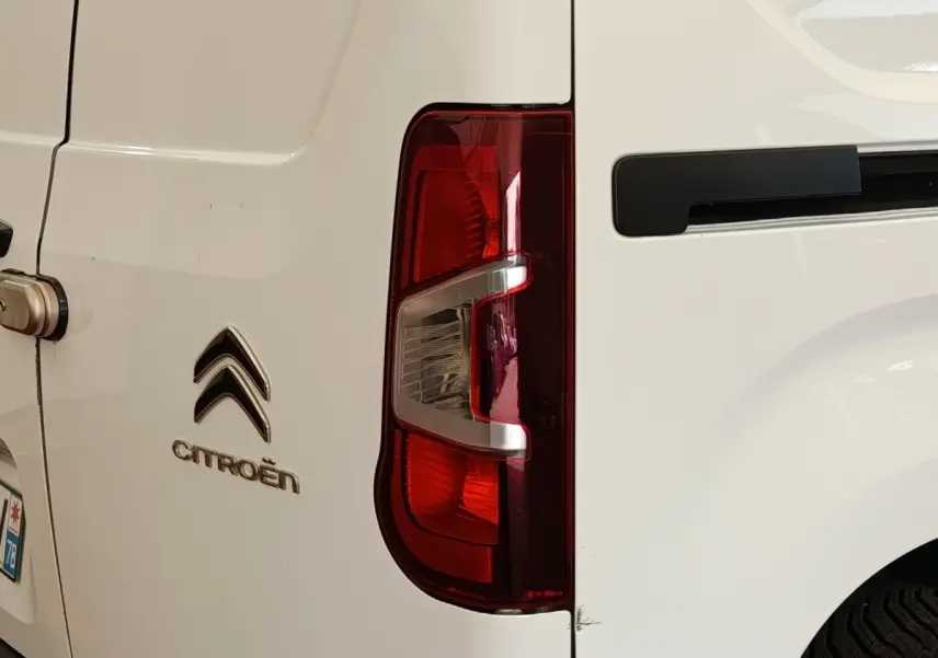 Gros plan sur le feu arrière droit et la porte arrière blanche d’un Citroën Berlingo utilitaire.