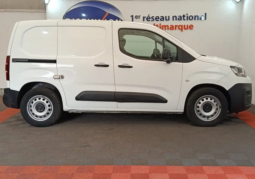 Vue de profil côté droit d’un utilitaire Citroën Berlingo blanc avec portes latérales pleines et jantes acier.
