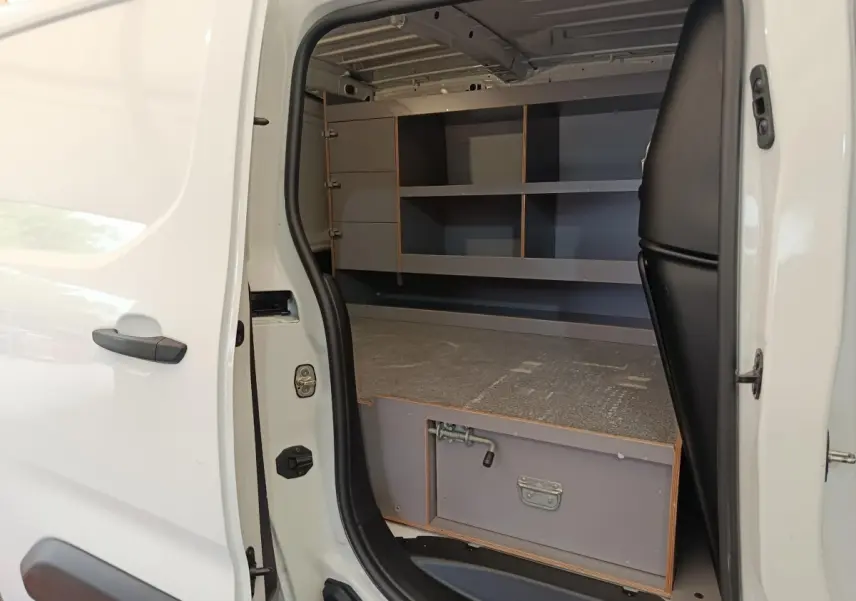 Vue latérale gauche du Citroën Berlingo blanc 2020 avec porte coulissante ouverte montrant l'aménagement intérieur de rangement.