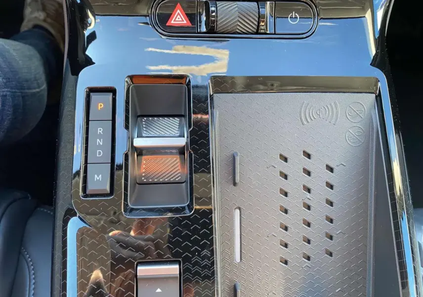 Gros plan sur la console centrale noire brillante du Citroën C5 Aircross hybride, avec sélecteur de vitesses et commandes tactiles.