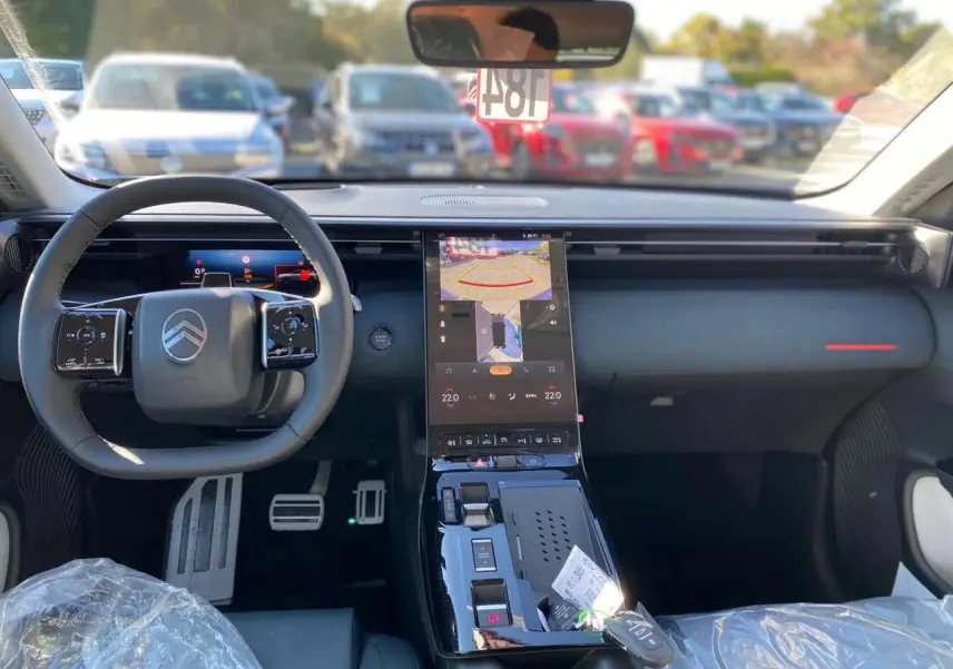 Vue intérieure avant du Citroën C5 Aircross 2026, tableau de bord noir avec écran tactile central et volant multifonction.