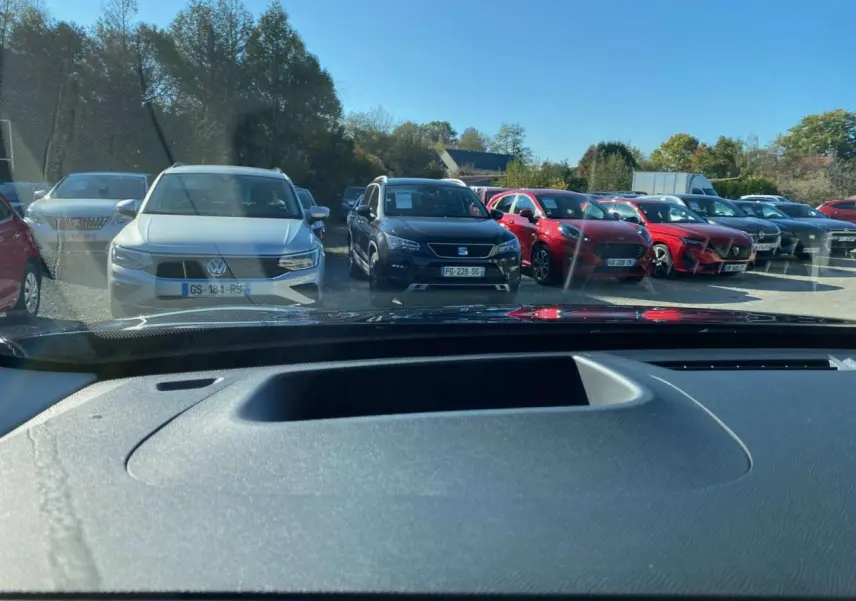 Vue depuis l'intérieur montrant le tableau de bord et le pare-brise, avec un Citroën C5 Aircross noir visible à l'extérieur.