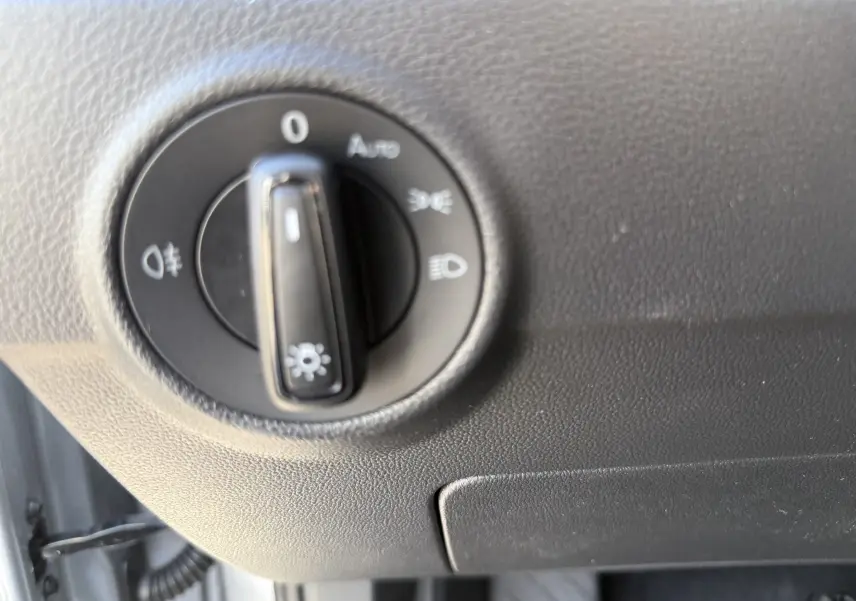 Gros plan sur le sélecteur d'éclairage intérieur du Volkswagen T-Roc 2025 gris pyrite, côté conducteur.