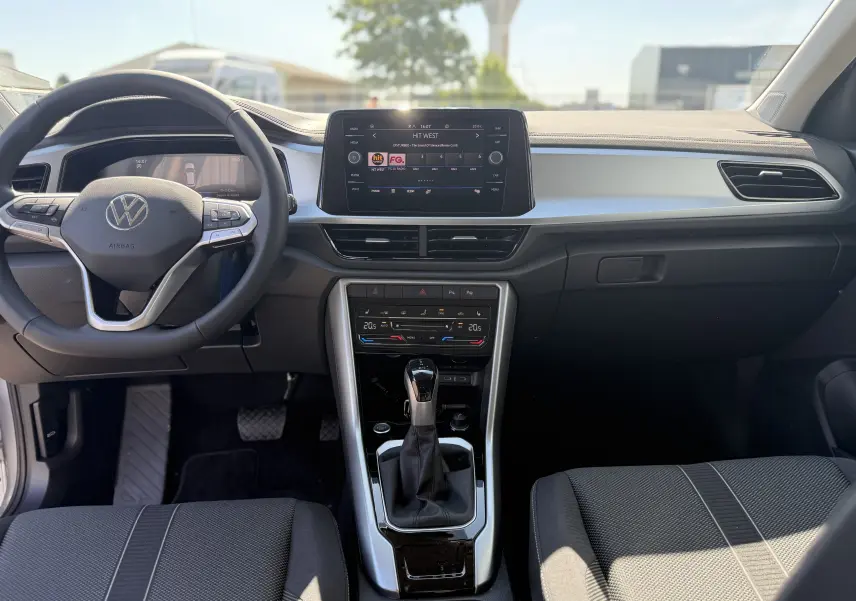 Vue intérieure avant du Volkswagen T-Roc 1.5 TSI 150 DSG7 LIFE 2025, tableau de bord moderne avec écran tactile et volant multifonction.