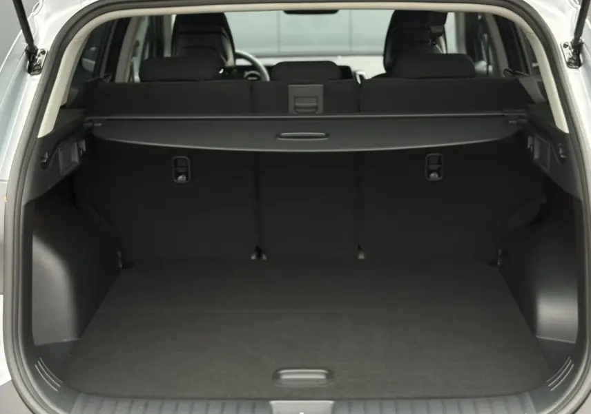 Coffre ouvert vu de l'arrière d'un KIA SPORTAGE gris perle, montrant l'espace de chargement et la plage arrière.