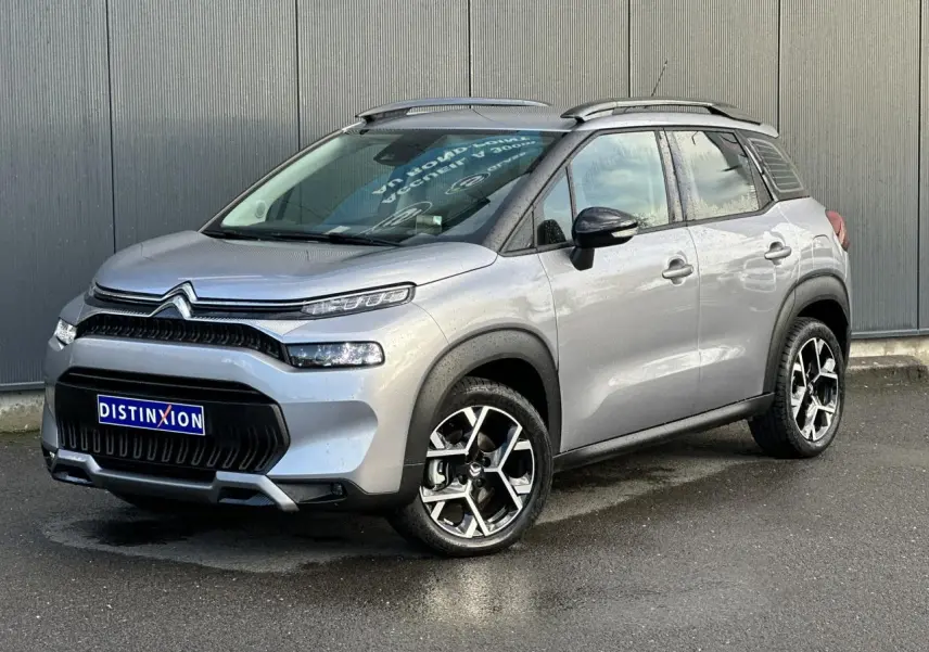 Citroën C3 Aircross gris Artense en 3/4 avant droit, avec jantes alliage 17'' et barres de toit noires.