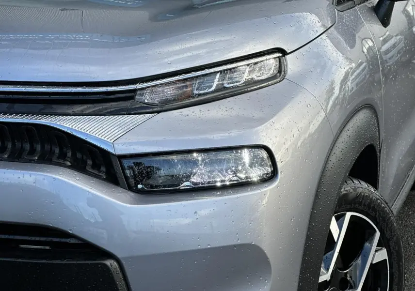 Gros plan sur l'avant droit gris Artense du Citroën C3 Aircross 2024 avec phares LED et jante alliage diamantée.