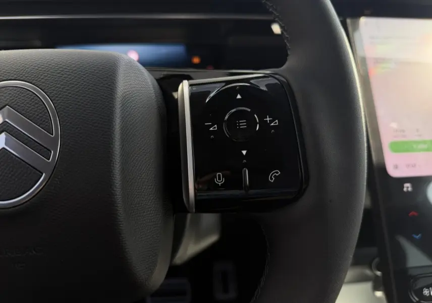 Gros plan sur le volant noir du Citroën C5 Aircross 2026 avec commandes tactiles et logo central argenté.