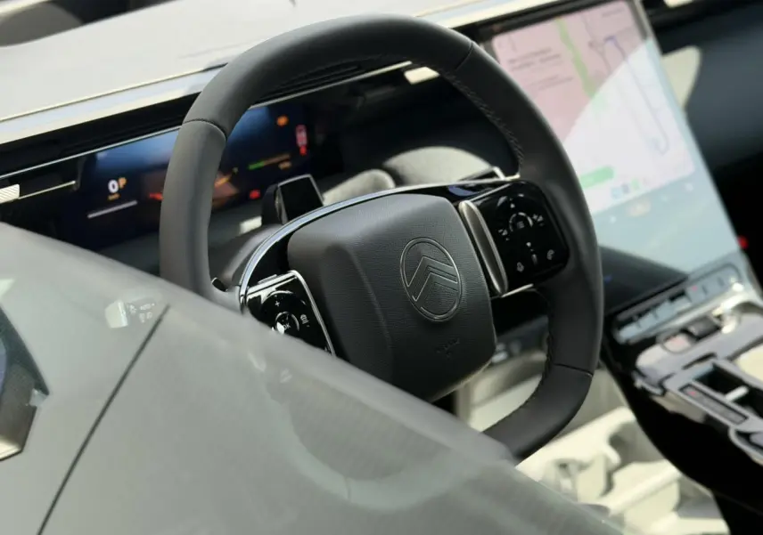 Gros plan sur le volant noir multifonctions et l'écran tactile vertical du tableau de bord du Citroën C5 Aircross.