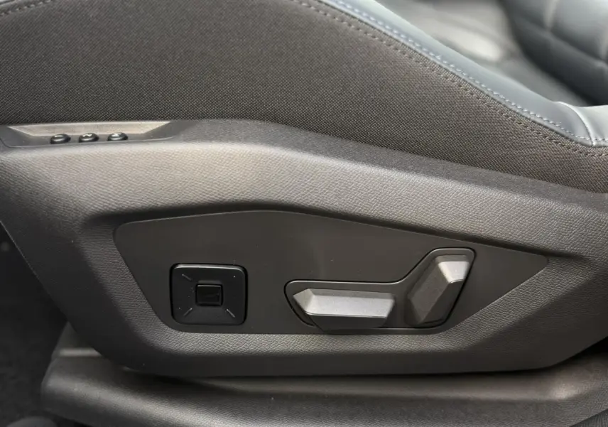 Gros plan sur les commandes électriques de réglage du siège avant côté conducteur du Citroën C5 Aircross noir Perla.