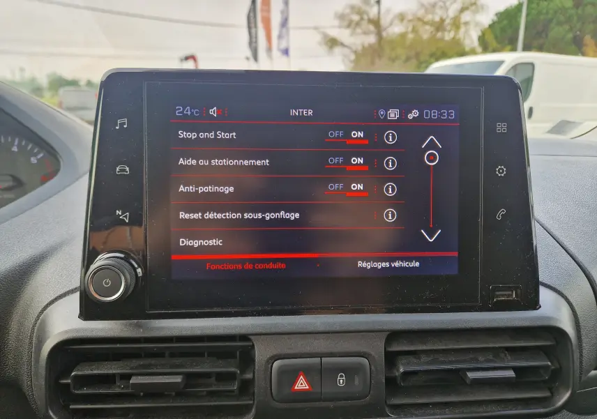 Écran tactile central du Peugeot Partner 2021 affichant les réglages d’aides à la conduite, avec commandes et ventilation visibles.