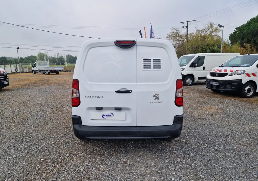 Vue arrière d’un utilitaire blanc Peugeot Partner Long 2021 avec logo et marquage VitalAire sur porte droite.