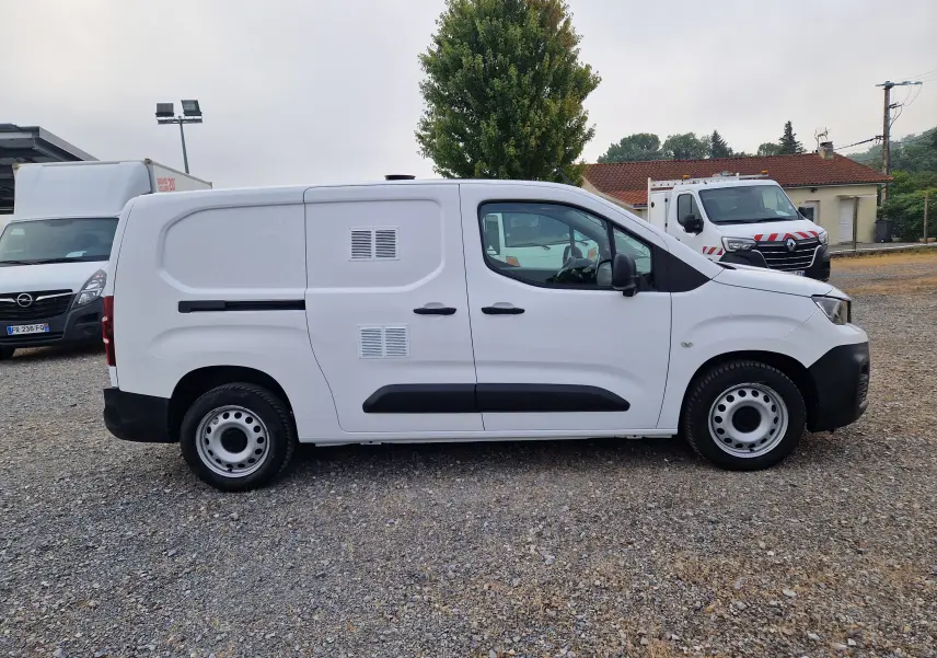Vue de profil côté droit d'un utilitaire Peugeot Partner blanc avec deux portes latérales et jantes acier.
