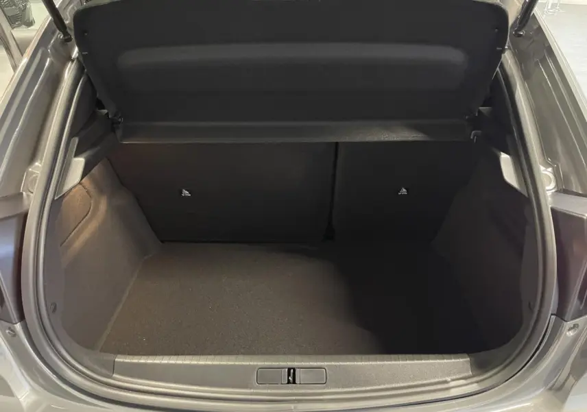 Coffre ouvert de la Peugeot 208 gris selenium, vue arrière montrant l'espace de chargement vide.