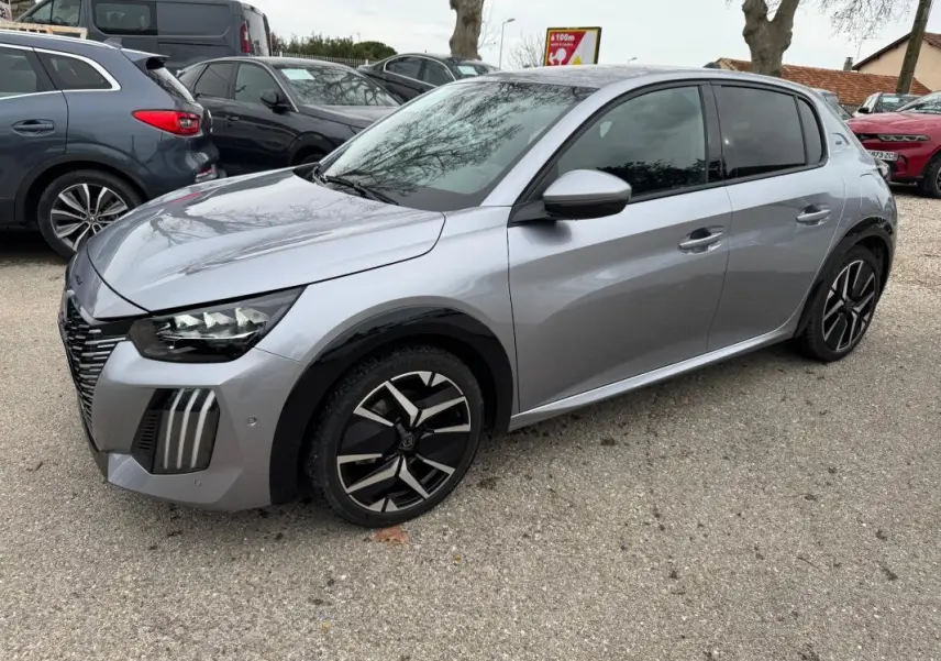 Peugeot 208 Hybrid gris vue 3/4 avant droit, jantes alliage 17 pouces et rétroviseurs dégivrants visibles.